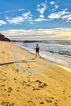 Man running in the beach at dawn soft waveÃ¢â¬â¢s bright blue sky, foot prints trace in sand